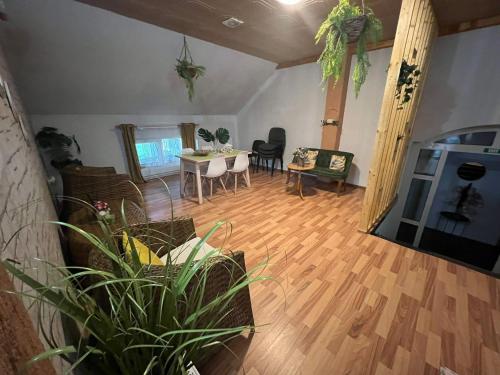 ein Wohnzimmer mit Holzboden und einem Tisch in der Unterkunft CASA ARIAN in Haţeg