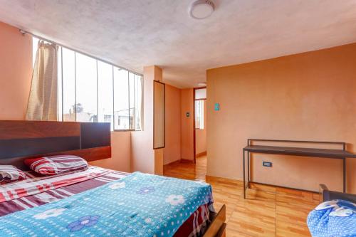 1 dormitorio con cama y escritorio. en Kely3 Cuarto Piso, en Lima