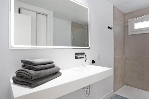 een witte badkamer met een wastafel en een spiegel bij Villa Santa Clara 21c in Chiclana de la Frontera