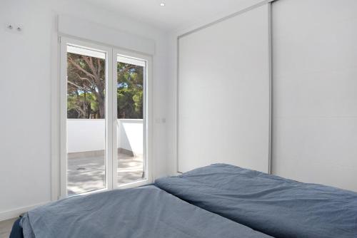 een slaapkamer met een bed en een groot raam bij Villa Santa Clara 21c in Chiclana de la Frontera