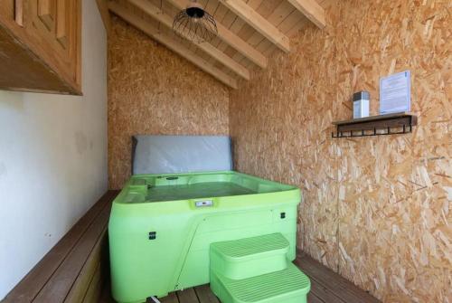 een groene wasmachine in een kamer met een muur bij La Chaume des Xettes / 10-14 pers SPA - Vue Lac in Gérardmer