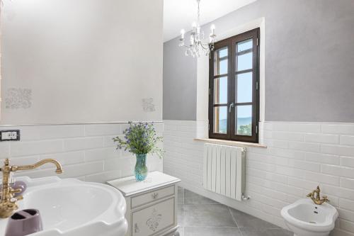 uma casa de banho branca com um lavatório e um WC em Villa Montepescini em Murlo