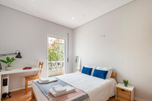 ein weißes Schlafzimmer mit einem Bett und einem Fenster in der Unterkunft Beautiful House in Matosinhos Beach - by Guest SPA in Matosinhos