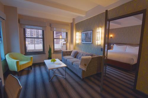 a hotel room with a couch and a bed at Hotel Edison Times Square in New York