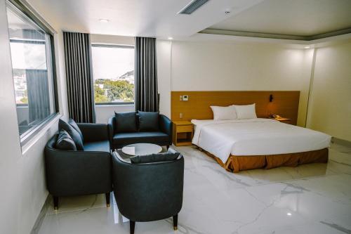a hotel room with a bed and two chairs at SUNRISE Hotel HA TIEN in Ha Tien