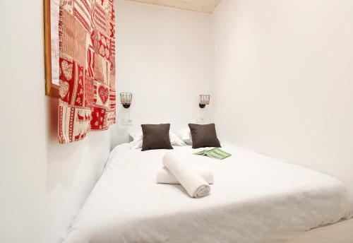 - une chambre blanche dotée d'un lit avec des draps et des oreillers blancs dans l'établissement Résidence du Brévent - Chamonix Village, à Chamonix-Mont-Blanc