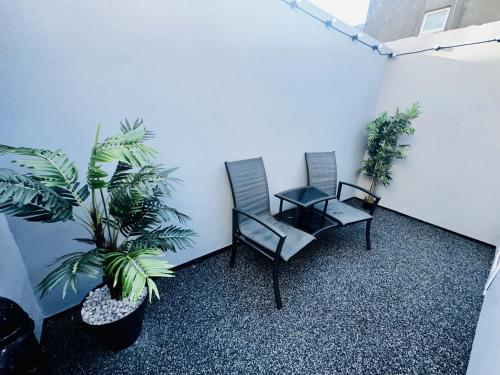 two chairs and a table in a room with plants at New osborne hot tub and jacuzzi suites in Blackpool