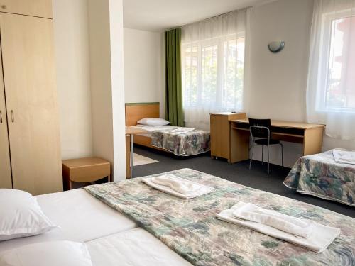 um quarto de hotel com duas camas e uma secretária em Mint Family Hotel em Ravda