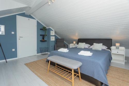 a bedroom with a blue bed with a bench at House for rent Serenity in Skradin