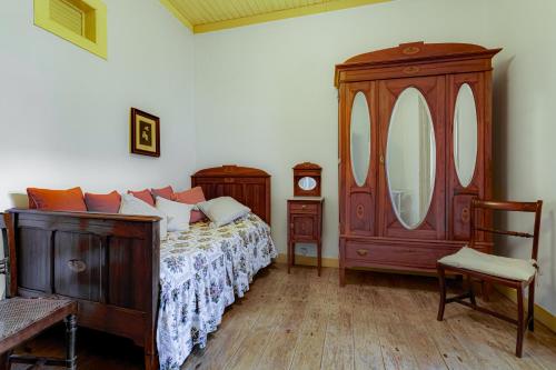 a bedroom with a bed and a dresser and a mirror at DOROTHEA HOUSE by Stay in Alentejo in Cercal