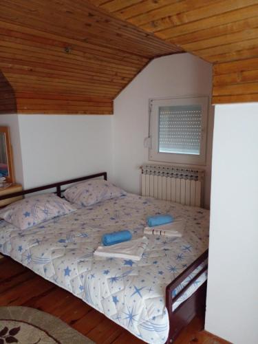 a bedroom with a bed with blue pillows on it at Idiličan brijeg in Višegrad