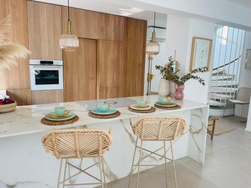 une cuisine avec un îlot avec trois plaques et des chaises dans l'établissement Moscowa# Ibiza, à Cannes