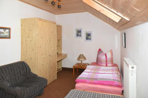 Cette chambre comprend un lit, un canapé et une chaise. dans l'établissement Haus Annemarie, à Goldkronach