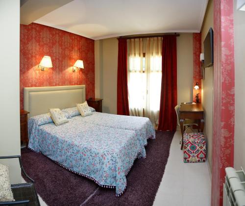 a bedroom with a bed and a red wall at Señorío de Los Bazán in Palacios de la Valduerna