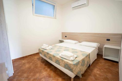 1 dormitorio con 1 cama con toallas en Appartamento Santa Lucia A, en Policastro Bussentino