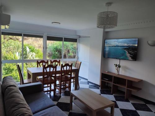 sala de estar con sofá, mesa y sillas en Apartamento en Playa Carvajal, en Fuengirola