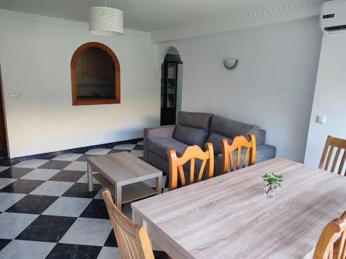 sala de estar con sofá, mesa y sillas en Apartamento en Playa Carvajal, en Fuengirola