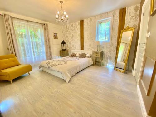 - une chambre avec un lit, un miroir et une chaise dans l'établissement Maison De Lavende, à Bessines-sur-Gartempe