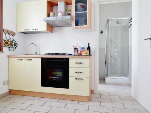プーラにあるLovely Studio in Pulaの白いキャビネットと黒い食器洗い機付きのキッチンが備わります。