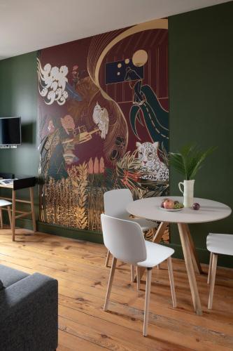 a living room with a table and a painting on the wall at MiHotel Gailleton in Lyon