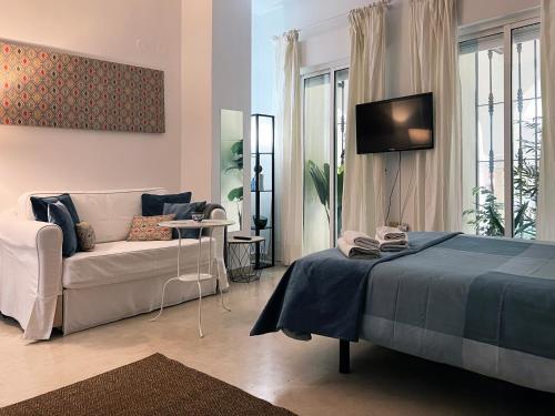salon z łóżkiem i kanapą w obiekcie Estudio Suite San Vicente - Aloha Sevilla w Sewilli