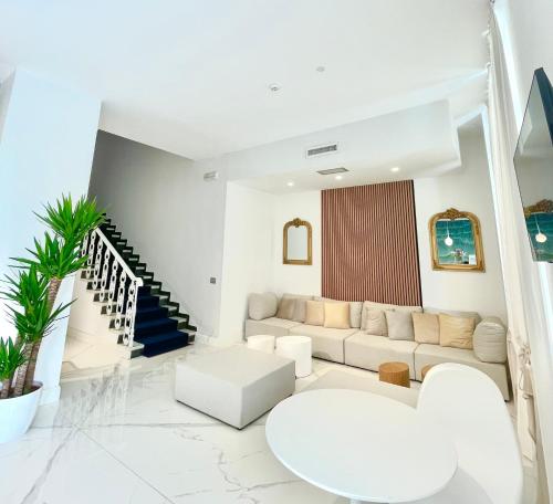 a living room with white furniture and a staircase at Hotel Tirreno in Marina di Massa