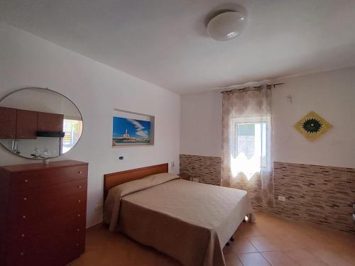 1 dormitorio con cama, espejo y ventana en Villa Elvira, en Vieste