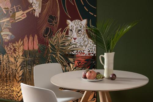 a table and chairs with a plate of fruit on it at MiHotel Gailleton in Lyon