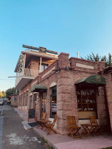 a brick building with tables and chairs outside of it at VinoOdor - ვინოოდორ in Tʼelavi