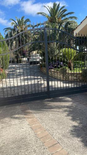 a metal gate in a parking lot with palm trees at Villa Marina B&B in Cleto