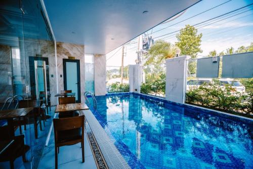 a swimming pool with a table and chairs in a house at SUNRISE Hotel HA TIEN in Ha Tien