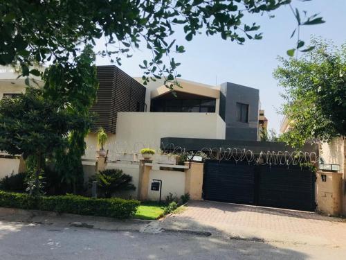 une maison blanche avec un garage noir dans l'établissement Family lodges, à Islamabad