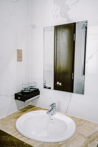 a bathroom with a sink and a mirror at SUNRISE Hotel HA TIEN in Ha Tien