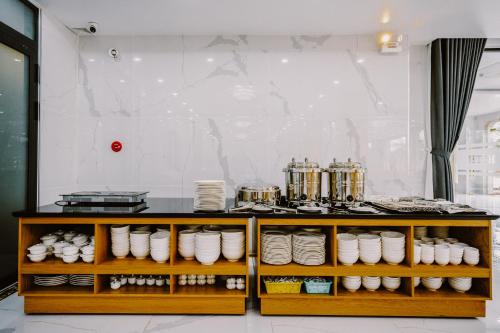 a counter with white plates and dishes on it at SUNRISE Hotel HA TIEN in Ha Tien