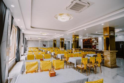 a dining room with tables and yellow chairs at SUNRISE Hotel HA TIEN in Ha Tien