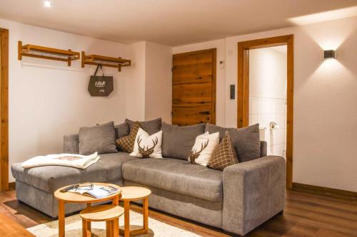 a living room with a gray couch and a table at Haus Franzi in Steeg