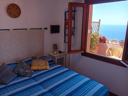 a bedroom with a bed and a large window at Belvedere-InfinityHolidays in Costa Paradiso