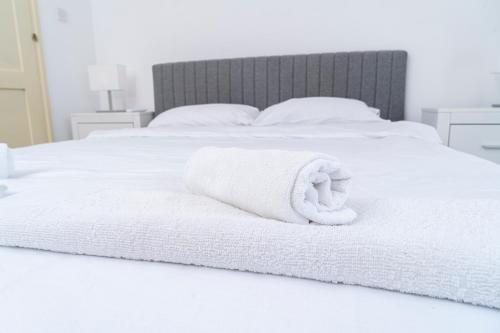 a white bed with a towel on it at Private room in shared flat in Nicosia