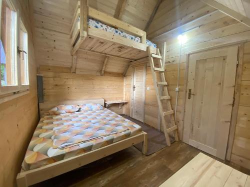 a wooden bedroom with a bunk bed and a ladder at ETHNO STAR Bojović in Gusinje