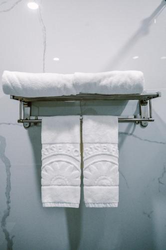 a towel rack with towels on a table with water at SUNRISE Hotel HA TIEN in Ha Tien