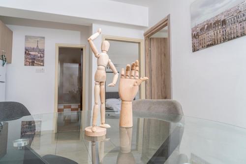 a wooden mannequin sitting on top of a glass table at Private room in shared flat in Nicosia