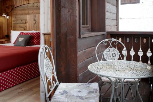 a table and chairs on a porch with a bed at Chalet Matterhorn Francois - Central Ski Chalet with SPA and Breakfast, 100mt lift in Breuil-Cervinia