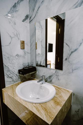 a bathroom with a sink and a mirror at SUNRISE Hotel HA TIEN in Ha Tien