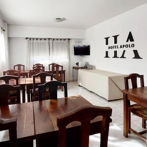 une salle à manger avec des tables, des chaises et une télévision dans l'établissement HOTEL APOLO NEUQUEN, à Neuquén