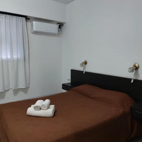 um quarto com uma cama com toalhas em HOTEL APOLO NEUQUEN em Neuquén