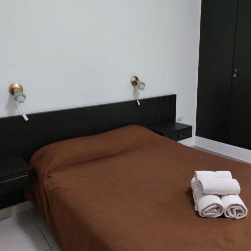 - une chambre avec un lit et 2 serviettes dans l'établissement HOTEL APOLO NEUQUEN, à Neuquén