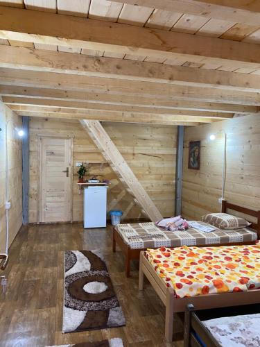 two beds in a room with wooden walls at Wooden houses Bojovic in Gusinje