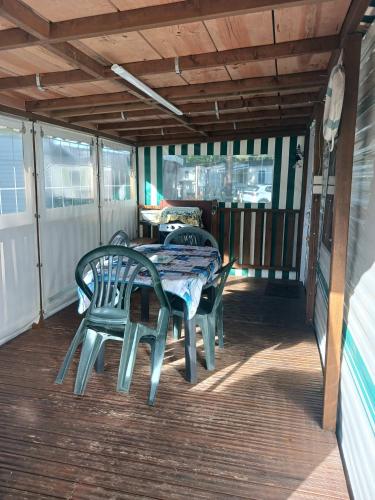 un patio avec une table et des chaises sur une terrasse dans l'établissement MH 343 LA TREMBLADE, à La Tremblade
