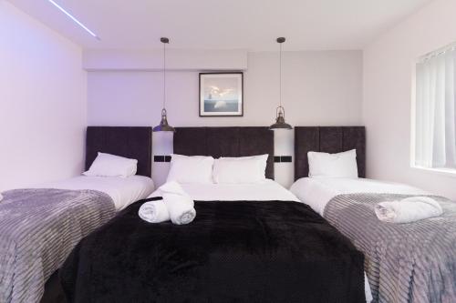 um quarto com três camas com toalhas em Fewston House em Leeds
