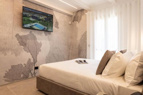 a bedroom with a bed with a tv on the wall at TENUTA FOGLIANI Resort & Natural Spa in Visciano